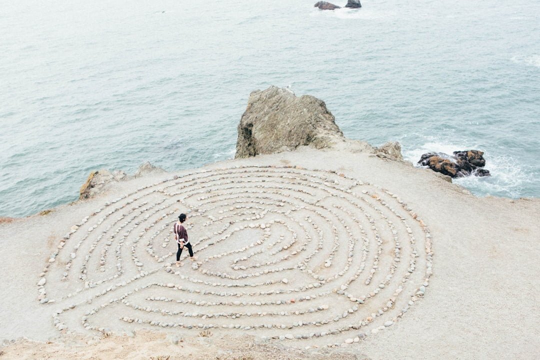Person walking inside a symbol drawn on the sand at the beach