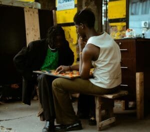 Two individuals engaged in a focused board game match in an urban outdoor setting.