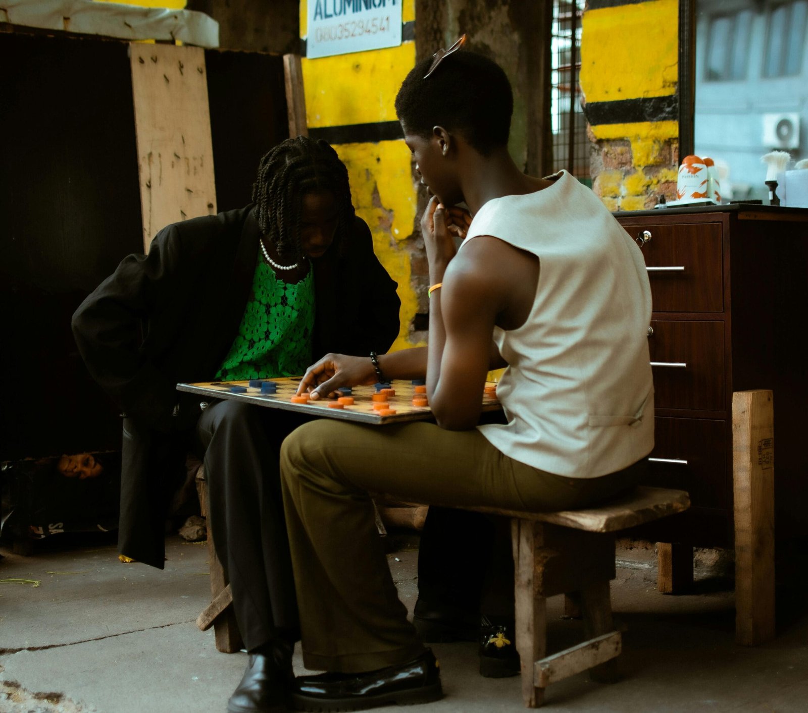 Two individuals engaged in a focused board game match in an urban outdoor setting.