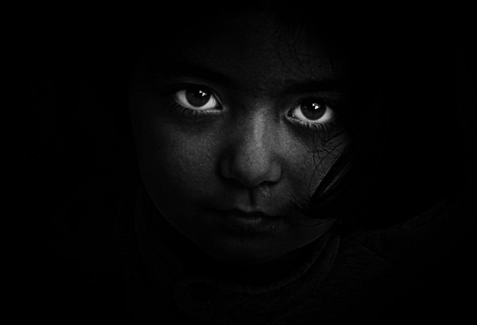 Who Am I: Stories of Misjudged People and Hidden Truths 1 Intense black and white portrait of a child with captivating eyes, evoking mystery and emotion.