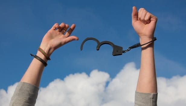 Breaking Free from Algorithmic Control: How Gen Z Can Heal 7 Symbolic image of freedom with open handcuffs against a bright blue sky.