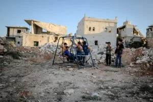 children play on a swing amidst the decaying ruins . childhood trauma, CPTSD, trauma response, nervous system dysregulation, highly sensitive person