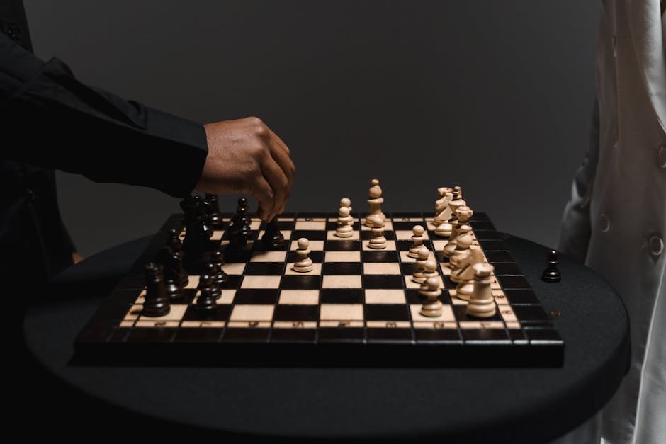 Two players strategizing over a chessboard, making a calculated move. terrorism, perpetual war, manipulation, politics, conspiracy, manufactured conflict.
